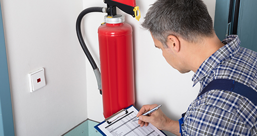 Technician documenting a fire extinguisher inspection